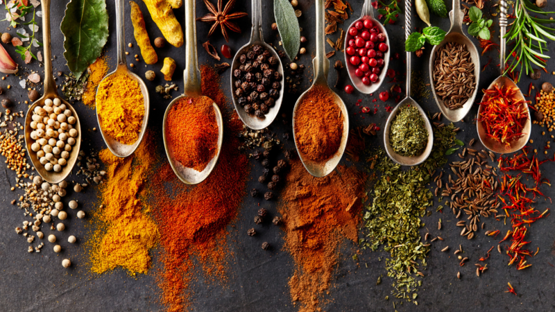 Several different spices on spoons.